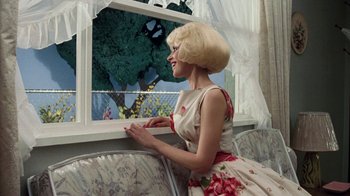 Movie still from “Little Shop of Horrors” (1986), directed by Frank Oz – A woman sitting in front of a window looking outside; Medium shot, Over the shoulder angle