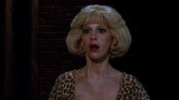 Movie still from “Little Shop of Horrors” (1986), directed by Frank Oz – A woman with blonde hair wearing a leopard print dress; Close Up shot, Over the shoulder angle