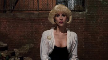 Movie still from “Little Shop of Horrors” (1986), directed by Frank Oz – A woman with blonde hair wearing a black top; Close Up shot, Over the shoulder angle