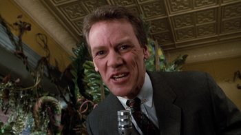 Movie still from “Little Shop of Horrors” (1986), directed by Frank Oz – A person wearing a suit and tie; Close Up shot, Low angle