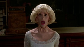 Movie still from “Little Shop of Horrors” (1986), directed by Frank Oz – A woman in a white dress with a surprised look on her face; Close Up shot, Low angle