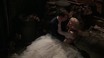 Movie still from “Little Shop of Horrors” (1986), directed by Frank Oz – A man and a woman dressed in wedding attire; Wide shot, High angle