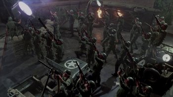 Movie still from “Little Shop of Horrors” (1986), directed by Frank Oz – A group of men in green fatigues are holding guns; Wide shot, High angle