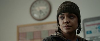 Movie still from “Little Woods” (2018), directed by Nia DaCosta – A woman wearing a hat in front of a wall clock; Close Up shot, Over the shoulder angle