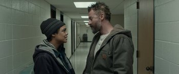 Movie still from “Little Woods” (2018), directed by Nia DaCosta – A man and a woman standing next to each other in a hallway; Medium shot, Over the shoulder angle