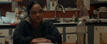 Movie still from “Little Woods” (2018), directed by Nia DaCosta – A girl sitting at a table in a kitchen; Close Up shot, Over the shoulder angle