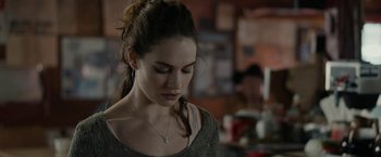 Movie still from “Little Woods” (2018), directed by Nia DaCosta – A young woman with a cross on her neck looking down; Close Up shot, Over the shoulder angle