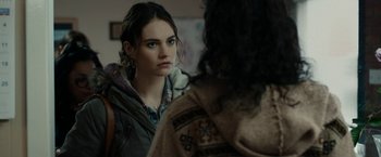 Movie still from “Little Woods” (2018), directed by Nia DaCosta – A young woman looking at a person in a hooded jacket; Close Up shot, Over the shoulder angle