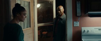 Movie still from “Little Woods” (2018), directed by Nia DaCosta – A man standing in front of an open door; Medium shot, Over the shoulder angle