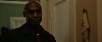 Movie still from “Little Woods” (2018), directed by Nia DaCosta – A man standing in front of a door in a room; Close Up shot, Over the shoulder angle