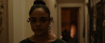 Movie still from “Little Woods” (2018), directed by Nia DaCosta – A woman with a bun is standing in a room; Close Up shot, Over the shoulder angle
