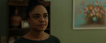 Movie still from “Little Woods” (2018), directed by Nia DaCosta – A young woman is standing in front of a wall; Close Up shot, Over the shoulder angle