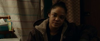Movie still from “Little Woods” (2018), directed by Nia DaCosta – A young woman wearing a brown jacket and a black shirt; Close Up shot, Over the shoulder angle