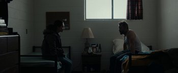 Movie still from “Little Woods” (2018), directed by Nia DaCosta – Two people are sitting in a living room talking; Wide shot, Over the shoulder angle