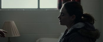 Movie still from “Little Woods” (2018), directed by Nia DaCosta – A young woman sitting in front of a window in a room; Close Up shot, Over the shoulder angle