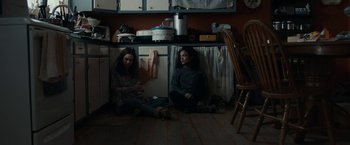 Movie still from “Little Woods” (2018), directed by Nia DaCosta – Two women sitting on the floor in a kitchen next to a sink; Wide shot, High angle