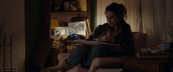 Movie still from “Little Woods” (2018), directed by Nia DaCosta – A woman sitting in a chair reading a book; Medium shot, Over the shoulder angle