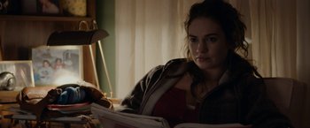 Movie still from “Little Woods” (2018), directed by Nia DaCosta – A woman sitting in a chair reading a newspaper; Medium shot, Over the shoulder angle