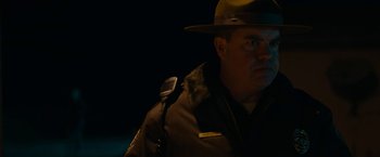 Movie still from “Little Woods” (2018), directed by Nia DaCosta – A man in a hat is holding a microphone in front of him; Close Up shot, Low angle