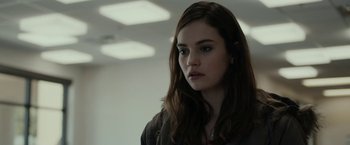 Movie still from “Little Woods” (2018), directed by Nia DaCosta – A woman with long brown hair is standing in a room; Close Up shot, Over the shoulder angle