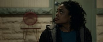 Movie still from “Little Woods” (2018), directed by Nia DaCosta – A woman looking up at the sky in a dark room; Close Up shot, Over the shoulder angle