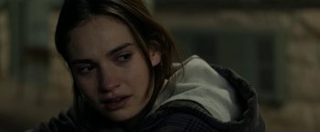 Movie still from “Little Woods” (2018), directed by Nia DaCosta – A young woman sitting on the ground with her eyes closed; Close Up shot, Over the shoulder angle