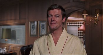 Movie still from “Live and Let Die” (1973), directed by Guy Hamilton – A person wearing a robe in a room; Close Up shot, Over the shoulder angle