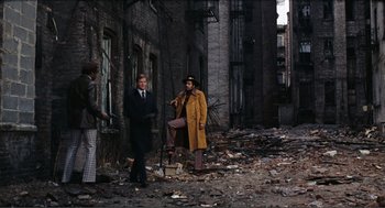 Movie still from “Live and Let Die” (1973), directed by Guy Hamilton – A group of people standing on the side of a building; Wide shot, High angle