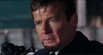 Movie still from “Live and Let Die” (1973), directed by Guy Hamilton – A person wearing a suit and tie; Close Up shot, Low angle