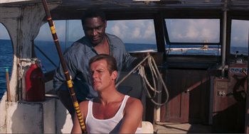 Movie still from “Live and Let Die” (1973), directed by Guy Hamilton – Two men on a boat in the water; Medium shot, High angle