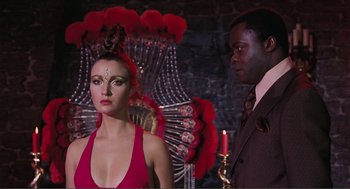 Movie still from “Live and Let Die” (1973), directed by Guy Hamilton – A man and a woman standing next to each other; Medium shot, Over the shoulder angle