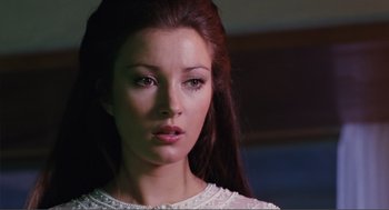 Movie still from “Live and Let Die” (1973), directed by Guy Hamilton – A person with long brown hair; Close Up shot, Low angle