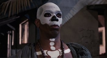 Movie still from “Live and Let Die” (1973), directed by Guy Hamilton – A man with a skull painted on his face; Close Up shot, Low angle