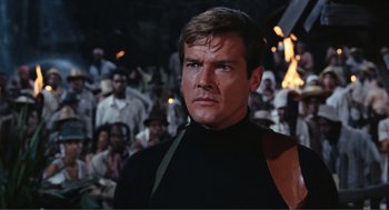 Movie still from “Live and Let Die” (1973), directed by Guy Hamilton – A man standing in front of a crowd; Close Up shot, Over the shoulder angle