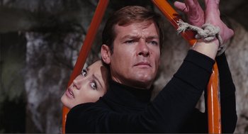 Movie still from “Live and Let Die” (1973), directed by Guy Hamilton – A man and a woman holding onto a piece of wood; Close Up shot, Low angle