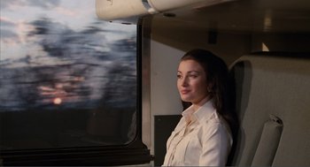 Movie still from “Live and Let Die” (1973), directed by Guy Hamilton – A woman standing in front of a window on a train; Medium shot, Low angle