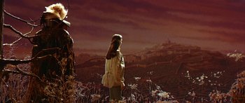 Movie still from “Labyrinth” (1986), directed by Jim Henson – A woman standing in front of a painting of a field; Extreme Wide shot, High angle