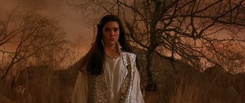 Movie still from “Labyrinth” (1986), directed by Jim Henson – A woman in a white shirt standing in front of a tree; Medium shot, Low angle