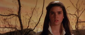 Movie still from “Labyrinth” (1986), directed by Jim Henson – A woman with long brown hair standing next to a tree; Close Up shot, High angle