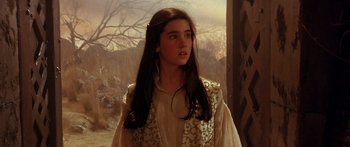 Movie still from “Labyrinth” (1986), directed by Jim Henson – A young girl wearing a white shirt and a white vest looking off into the distance; Close Up shot, Over the shoulder angle