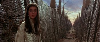 Movie still from “Labyrinth” (1986), directed by Jim Henson – A young woman standing in front of a brick wall; Close Up shot, Over the shoulder angle