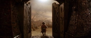 Movie still from “Labyrinth” (1986), directed by Jim Henson – An image of a person walking through an open gate; Wide shot, Low angle