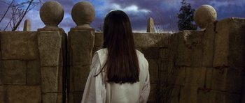 Movie still from “Labyrinth” (1986), directed by Jim Henson – A woman standing in front of a stone wall; Medium shot, Low angle
