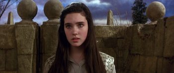 Movie still from “Labyrinth” (1986), directed by Jim Henson – A young woman with long black hair wearing a white shirt; Close Up shot, Over the shoulder angle