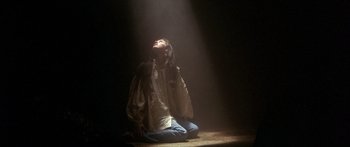 Movie still from “Labyrinth” (1986), directed by Jim Henson – A woman sitting on the ground in the light; Medium shot, Low angle