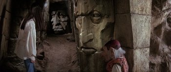 Movie still from “Labyrinth” (1986), directed by Jim Henson – A man standing in front of a statue; Close Up shot, High angle