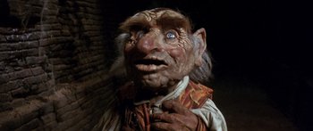Movie still from “Labyrinth” (1986), directed by Jim Henson – An old man with blue eyes is looking at the camera; Close Up shot, Low angle