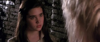 Movie still from “Labyrinth” (1986), directed by Jim Henson – A young woman with long black hair looking at the camera; Close Up shot, Over the shoulder angle