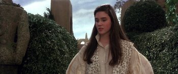Movie still from “Labyrinth” (1986), directed by Jim Henson – A young woman in a white shirt standing next to a hedge; Medium shot, Over the shoulder angle