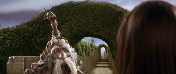Movie still from “Labyrinth” (1986), directed by Jim Henson – An image of an old man with a long beard in the middle of a garden path; Close Up shot, Low angle